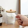 Transparent acrylic cotton ball holder with a bamboo lid for dust prevention, suitable for various spaces