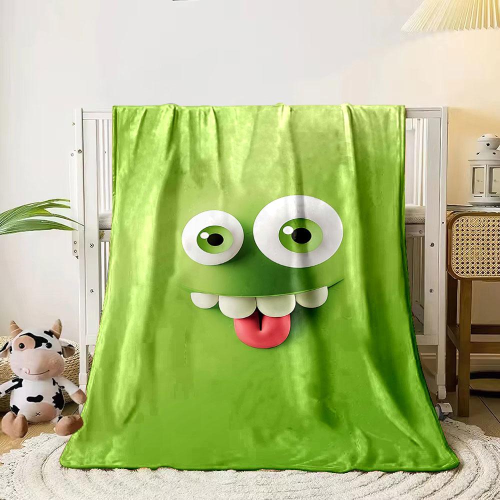 A playful green cartoon face with big eyes, teeth, and a sticking-out tongue. for all seasons blanket lunch break throw gift