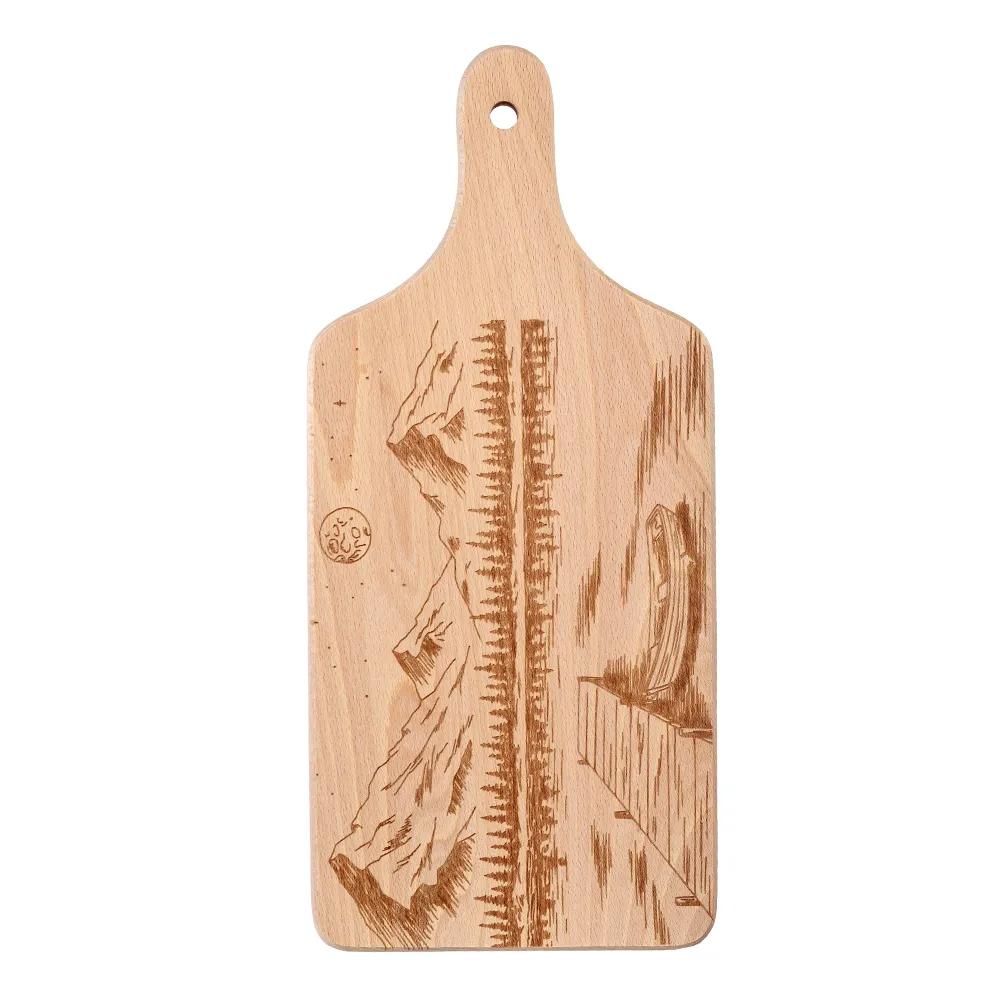 Wooden chopping board with engraved boat and mountains