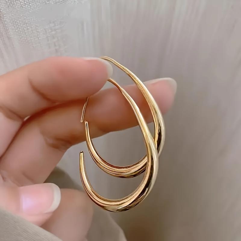 A Pair Of Minimalist Chic Teardrop-shaped Hoop Earrings, Exuding Elegance, Perfect For Ladies To Wear To Parties And Vacations.