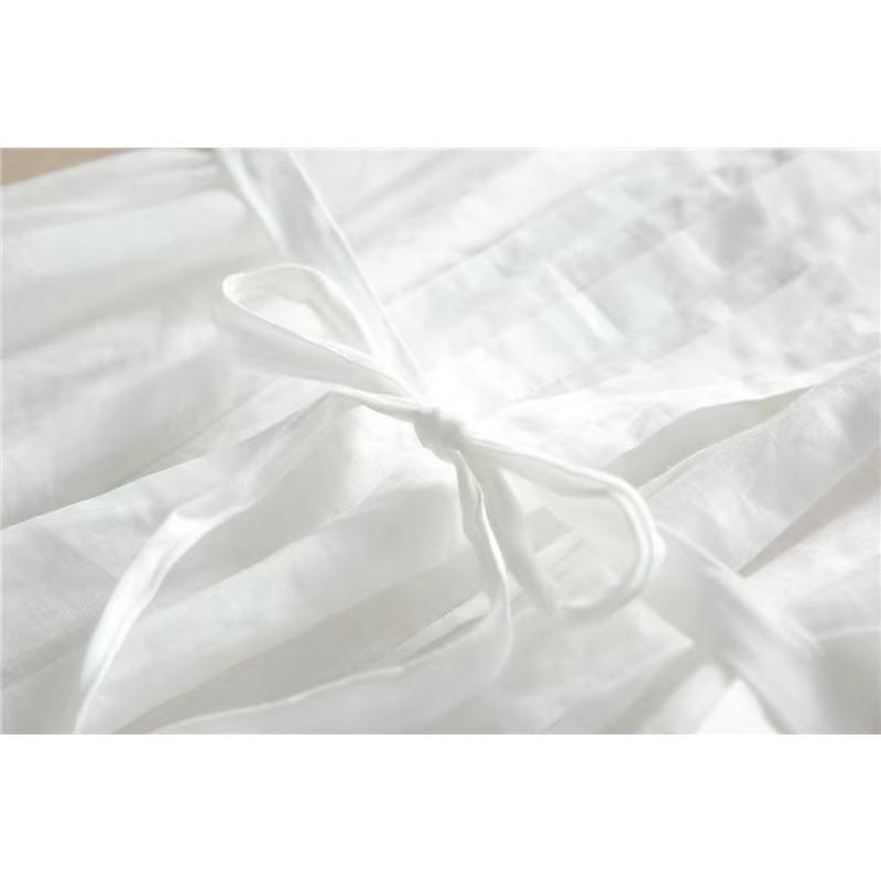 Женщина в белом платье со шнуровкой и приталенной талией